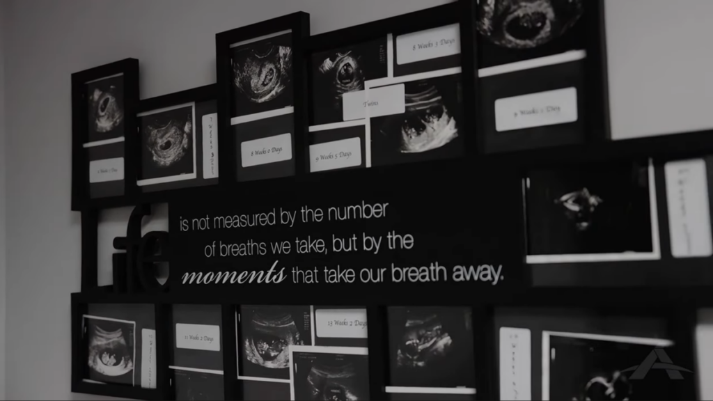 A wall display of framed ultrasound images surrounds a quote that reads: "Life is not measured by the number of breaths we take, but by the moments that take our breath away."