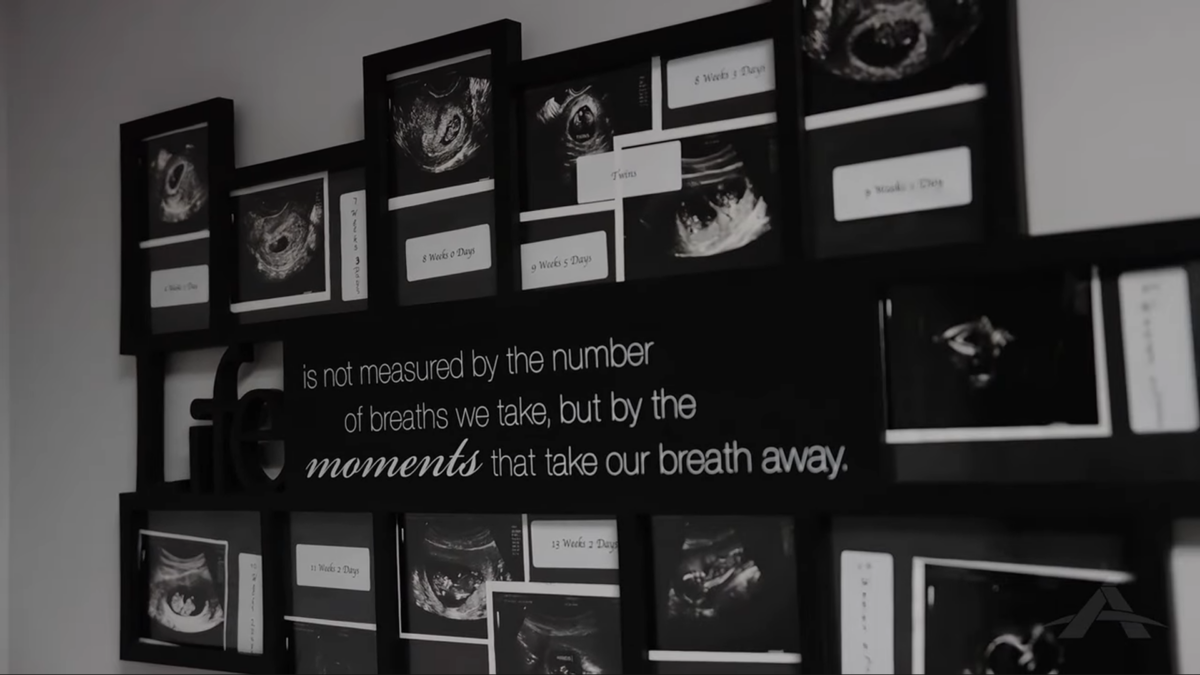 A wall display of framed ultrasound images surrounds a quote that reads: "Life is not measured by the number of breaths we take, but by the moments that take our breath away."